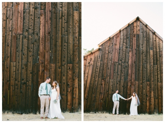 Couple standing near wooden wall on their wedding day