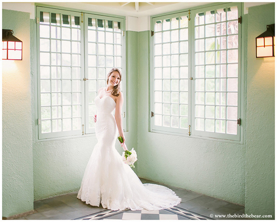 Beautiful bride in a wedding dress by a window with natural light