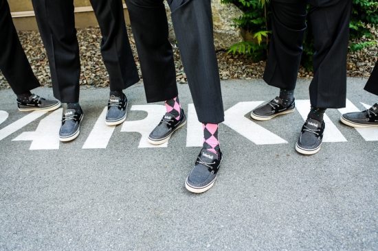 Groomsmen in suits and casual shoes on a parking spot