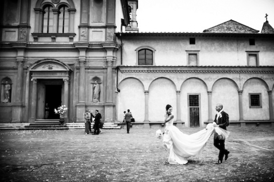Bride and groom with veil walking after wedding in monochrome style