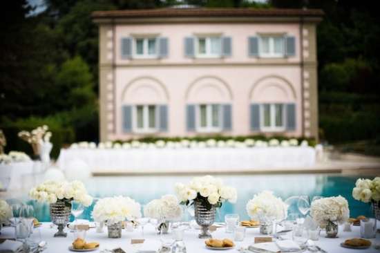 Elegant wedding reception with flowers by the pool