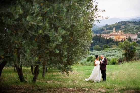 Bride and groom embrace in a Tuscan landscape at their wedding