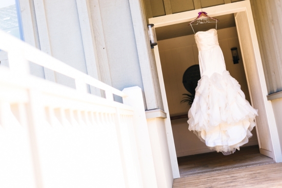 Elegant white wedding dress hanging in an open doorway