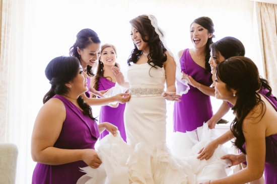 Bride surrounded by bridesmaids getting ready for her wedding day