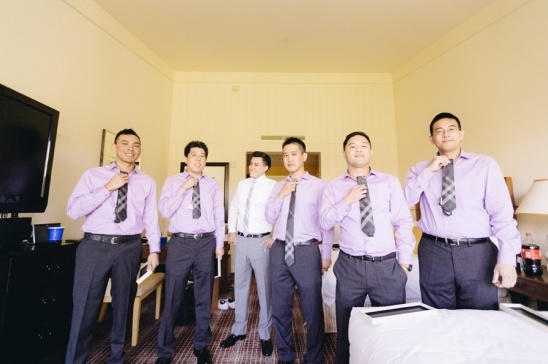 Groomsmen in lavender shirts adjusting their ties before the wedding