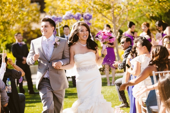 Happy bride and groom walking down the aisle on a sunny wedding day