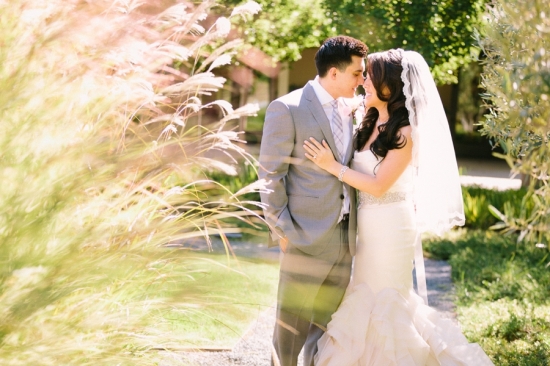 Newlyweds sharing an intimate moment in a sunny outdoor wedding