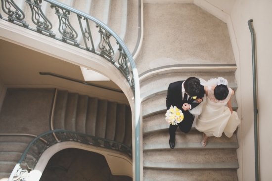 Wedding couple walking down the spiral staircase after ceremony