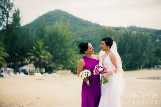 Bride and bridesmaid at a beach wedding smiling