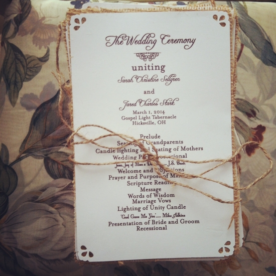 Wedding ceremony program tied with twine, floral background