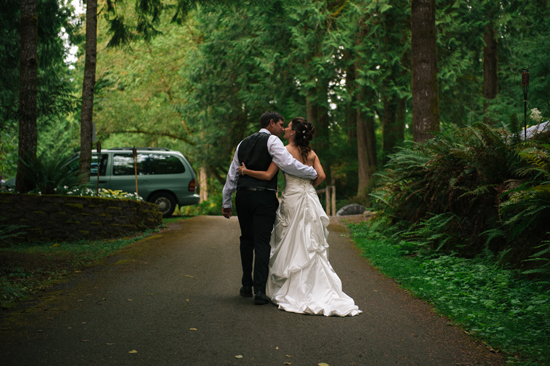 Newlyweds walking hand in hand on a path in a forest setting