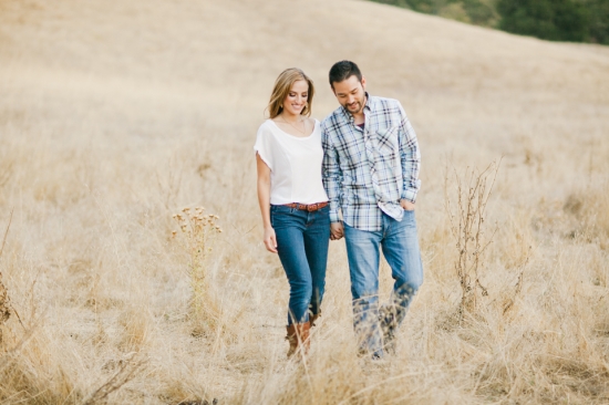 Couple walking together hand in hand through a golden field