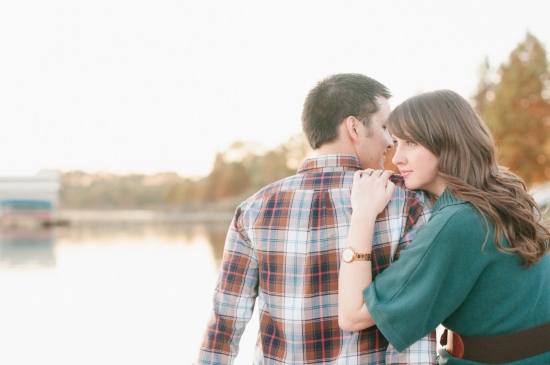 Romantic couple embracing by a lake at sunset