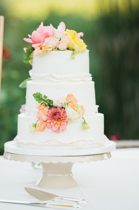 white wedding cake with bright floral accents
