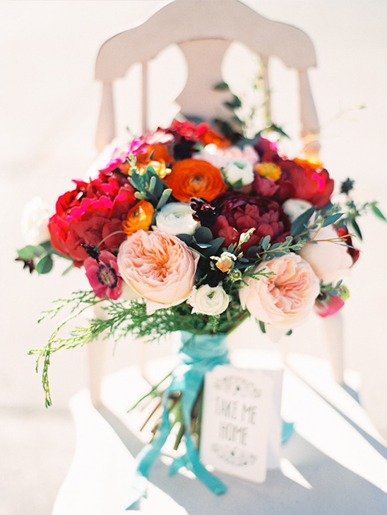 Vibrant wedding bouquet with pink, red, and orange flowers