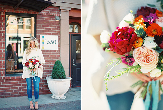 Woman holding vibrant autumn bouquet outside shop