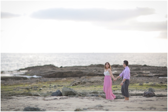 Couple holding hands walking on the beach near the ocean