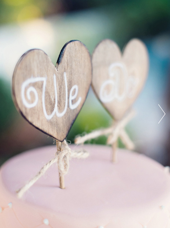 Heart shaped cake topper saying We do for a wedding ceremony