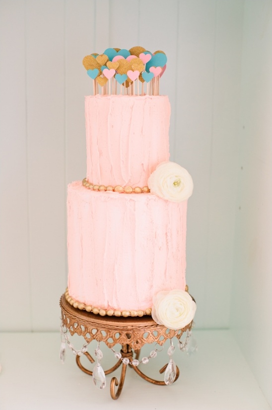 pink tiered cake with heart toppers