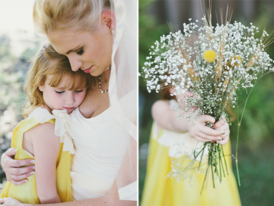 Bride and flower girl embrace, holding a bouquet of flowers