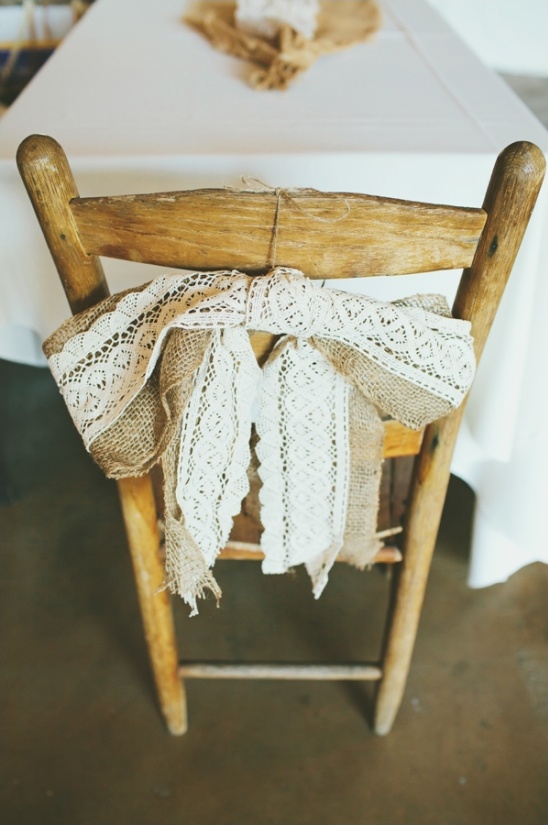 Rustic wooden chair decorated with burlap and lace bow
