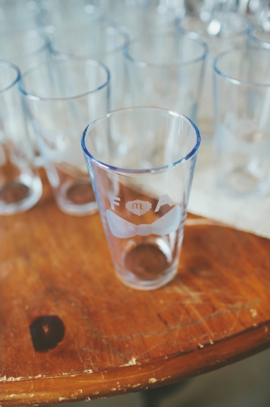Glass with a bow tie and F A M on a wooden table
