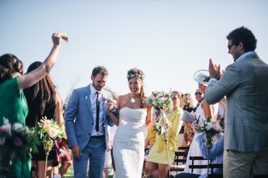 Wedding ceremony guests cheering couple
