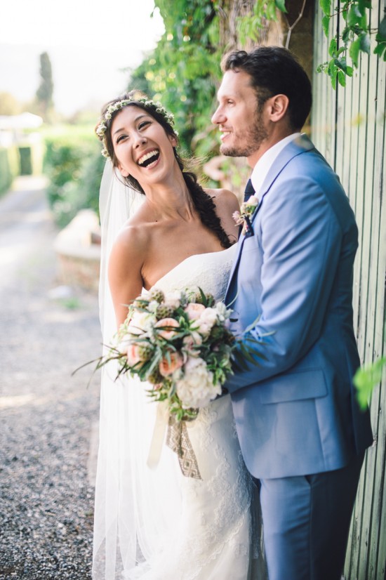 Laughing bride and groom embrace outdoors wedding day