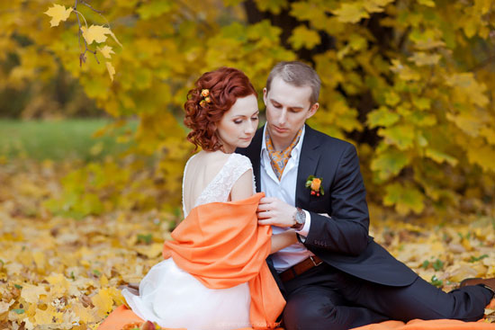 Autumn wedding couple in love, embracing amongst fall leaves