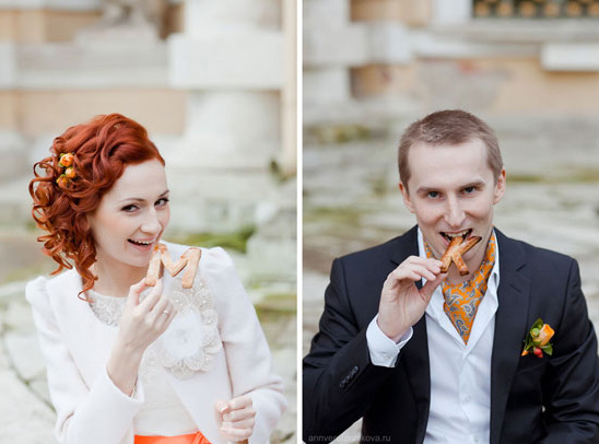 Bride and groom playfully holding initial letter cookies