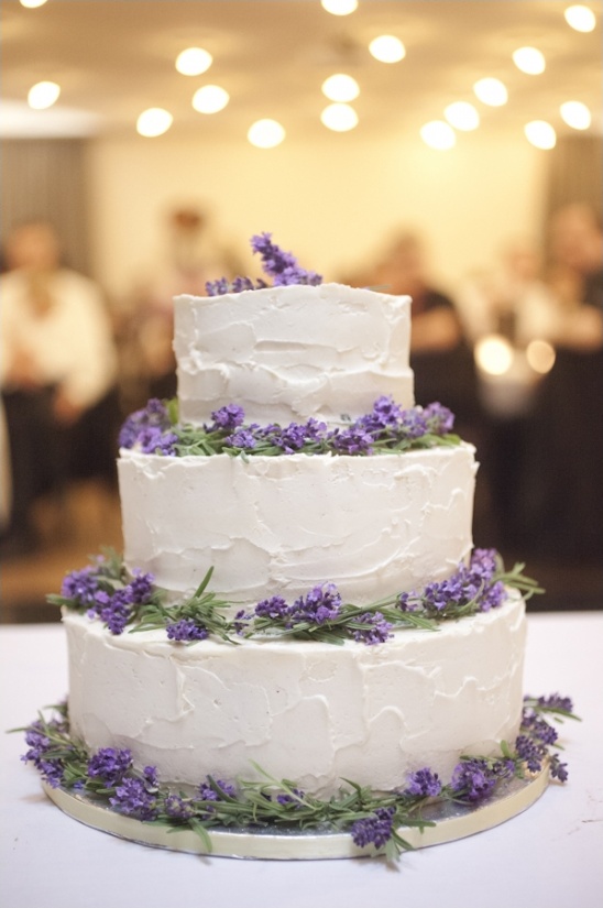 Three tier wedding cake with white frosting and lavender