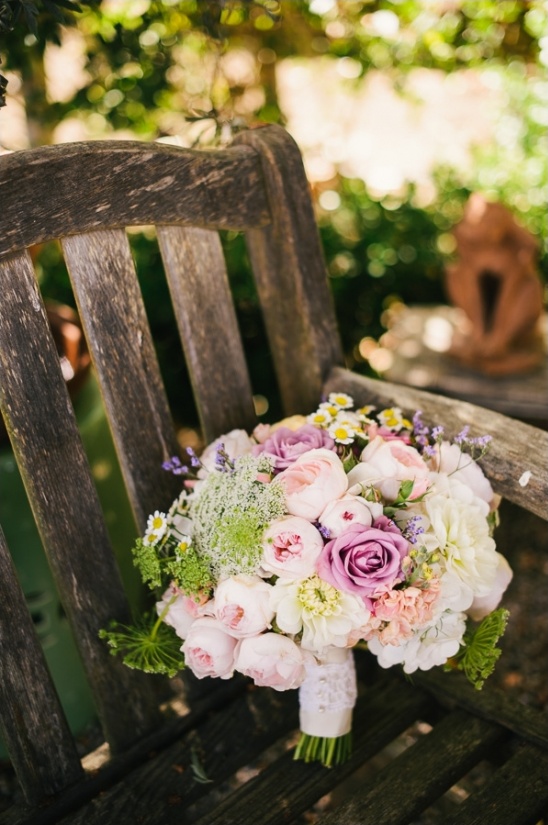 Pink and purple bouquet rests on a wooden bench