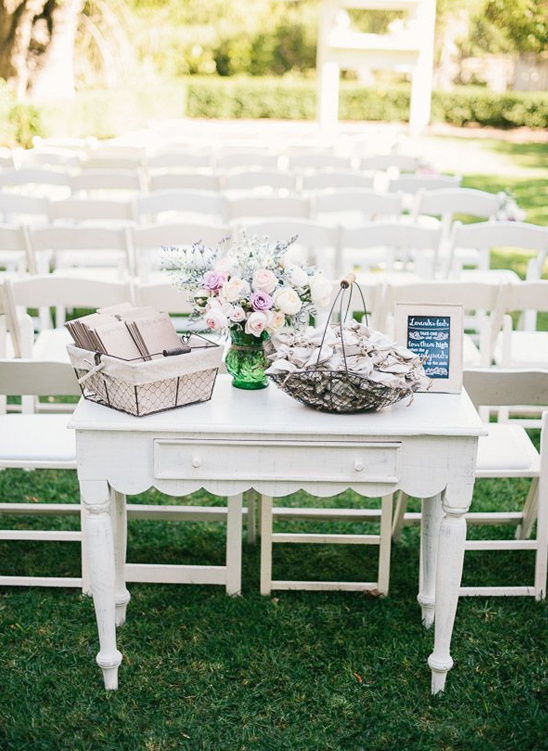 Outdoor wedding with white chairs and flower decor