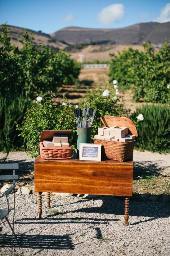 Wooden table with gifts in baskets, outdoors