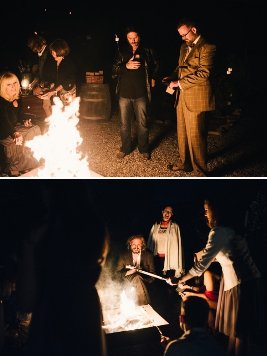 People roasting marshmallows around bonfire at night