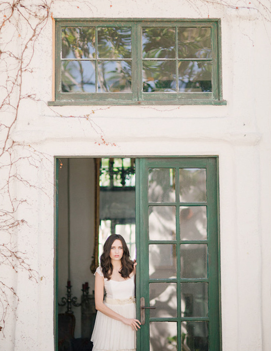 Bride in elegant gown near green door