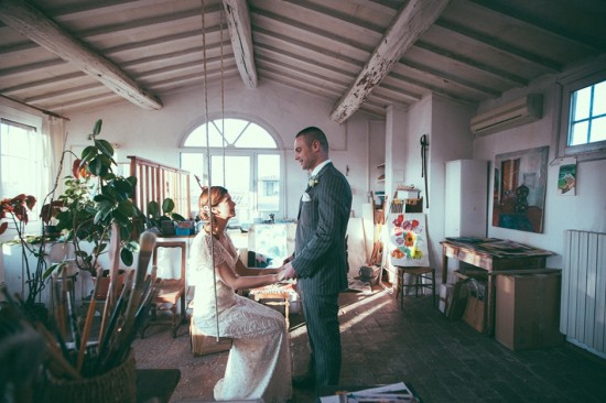 Bride and groom hold hands in art studio