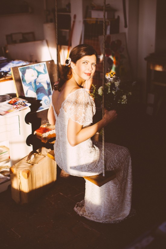 Bride in a white dress sits on a swing