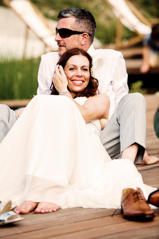 Happy bride and groom relaxing on a wooden deck after wedding