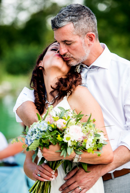 Newlyweds share a tender kiss at their outdoor wedding ceremony