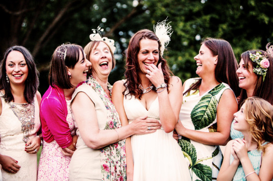 Joyful bride and bridesmaids laughing together at a wedding ceremony