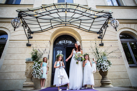Smiling bride with three flower girls at Chateau Mcely