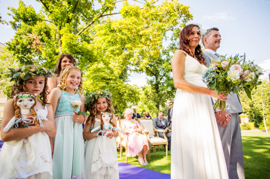 Bride groom and flower girls at a sunny outdoor wedding