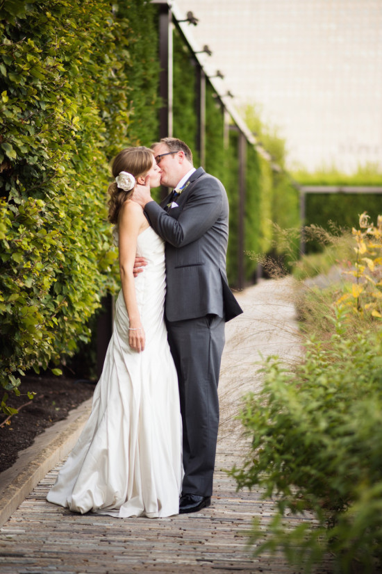 Bride and groom share a kiss outdoors at their wedding