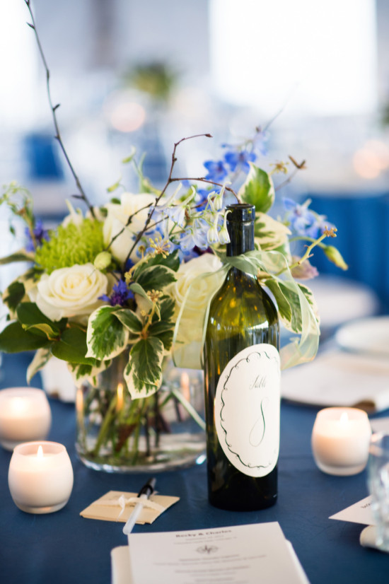 Elegant wedding centerpiece with wine bottle and flowers