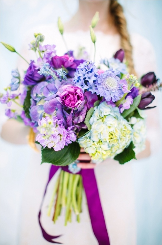 Bride holding vibrant purple hydrangea flower bouquet