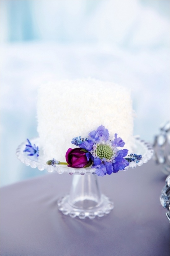 Wedding cake decorated with purple and blue flowers