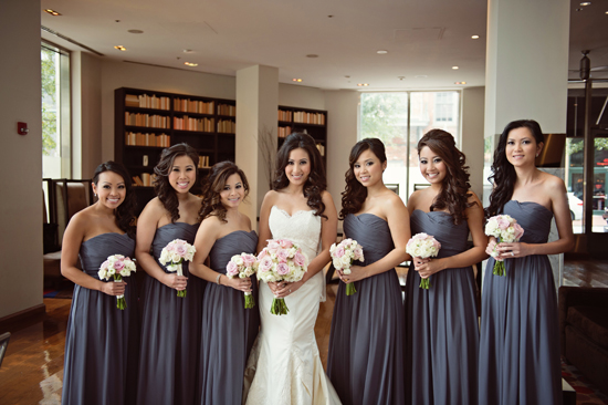 Beautiful bride with bridesmaids in gray dresses holding bouquets