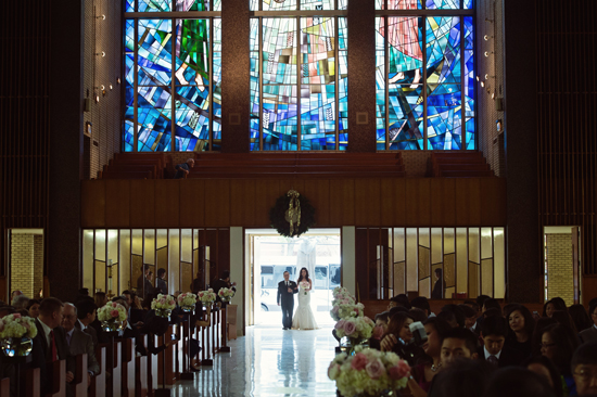 Bride walks down aisle at wedding ceremony in church
