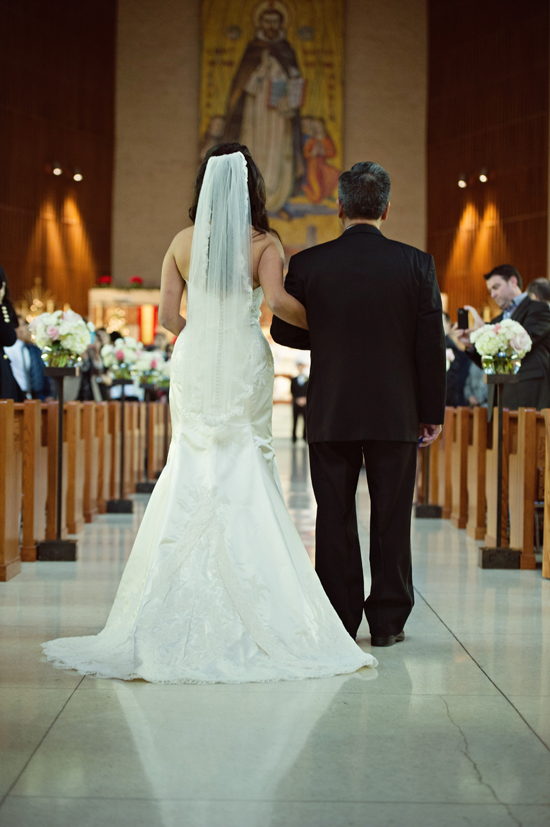 Bride and father walking down aisle at church wedding
